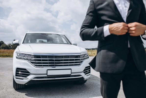 Handsome business man by the white car